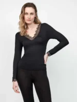 Maglia intima termica manica lunga scollo a V con dettaglio in pizzo – Gisela La maglia intima termica manica lunga scollo a V con dettaglio in pizzo Gisela è il capo perfetto per chi cerca comfort, femminilità e funzionalità in un unico prodotto. Pensata per accompagnarti durante le stagioni più fredde, questa maglia intima termica manica lunga scollo a V con dettaglio in pizzo Gisela unisce materiali di alta qualità a un design elegante e curato nei minimi dettagli. Realizzata con tessuti termici innovativi, la maglia intima termica manica lunga scollo a V con dettaglio in pizzo Gisela garantisce un eccellente isolamento dal freddo, mantenendo la pelle calda e asciutta per tutto il giorno. La sua struttura traspirante permette una perfetta gestione dell’umidità, rendendola ideale sia per l’uso quotidiano che per le giornate più dinamiche. Uno degli elementi distintivi di questa maglia intima termica manica lunga scollo a V con dettaglio in pizzo Gisela è senza dubbio il raffinato scollo a V impreziosito da un delicato inserto in pizzo. Questo dettaglio dona un tocco di eleganza e sensualità, trasformando un semplice capo intimo in un vero alleato di stile. Perfetta da indossare anche sotto capi leggermente scollati, la maglia intima termica manica lunga scollo a V con dettaglio in pizzo Gisela si adatta facilmente a diversi outfit. La vestibilità della maglia intima termica manica lunga scollo a V con dettaglio in pizzo Gisela è studiata per aderire al corpo senza costringere. Il tessuto elasticizzato segue le linee naturali, valorizzando la silhouette e garantendo massima libertà di movimento. Le cuciture sono sottili e discrete, pensate per risultare invisibili sotto i vestiti e offrire un comfort superiore durante tutta la giornata. Questa maglia intima termica manica lunga scollo a V con dettaglio in pizzo Gisela è ideale per chi non vuole rinunciare alla femminilità nemmeno nei mesi più freddi. Il pizzo, elegante ma non eccessivo, rende il capo versatile e adatto sia a look casual che più ricercati. Indossata sotto una camicia, un maglione o una giacca, la maglia intima termica manica lunga scollo a V con dettaglio in pizzo Gisela diventa un elemento invisibile ma fondamentale del tuo guardaroba. Dal punto di vista pratico, la maglia intima termica manica lunga scollo a V con dettaglio in pizzo Gisela è facile da lavare e mantiene la sua forma anche dopo numerosi utilizzi. I materiali resistenti assicurano una lunga durata nel tempo, rendendola un investimento intelligente per affrontare l’inverno con stile e comodità. Se stai cercando un capo che unisca estetica e performance, la maglia intima termica manica lunga scollo a V con dettaglio in pizzo Gisela è la scelta perfetta. Ideale per chi desidera sentirsi sempre a proprio agio, senza rinunciare a un tocco di eleganza anche nei dettagli più nascosti. Scegli la qualità e il design di una maglia intima termica manica lunga scollo a V con dettaglio in pizzo Gisela e trasforma il tuo modo di vivere l’intimo quotidiano. Perfetta per ogni occasione, questa maglia intima termica manica lunga scollo a V con dettaglio in pizzo Gisela diventerà presto un must-have indispensabile nel tuo armadio.