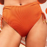 Bikini vita alta, un capo pensato per valorizzare la silhouette con eleganza e comfort. Questo bikini vita alta foderato con laccetti regolabili sui fianchi firmato Gisela è la scelta ideale per chi desidera unire stile, praticità e tendenza in un unico look da spiaggia. Il design del bikini vita alta è studiato per offrire una vestibilità impeccabile: la mutandina avvolgente aiuta a modellare delicatamente i fianchi e a slanciare la figura, rendendolo perfetto per ogni tipo di corpo. Grazie alla vita alta, questo bikini vita alta dona un effetto shaping naturale, molto apprezzato da chi cerca un capo che sappia valorizzare senza costringere. La presenza della fodera interna aumenta il comfort e garantisce una sensazione piacevole sulla pelle, anche dopo molte ore di utilizzo. Uno degli elementi distintivi di questo bikini vita alta sono i laccetti regolabili sui fianchi: un dettaglio non solo estetico ma anche funzionale. I laccetti permettono di adattare perfettamente il capo alla propria fisicità, offrendo una vestibilità personalizzata. Questo rende il bikini vita alta con laccetti particolarmente versatile e adatto sia a chi preferisce una copertura maggiore sia a chi desidera regolare l’altezza della sgambatura. Il tessuto di alta qualità utilizzato da Gisela garantisce resistenza, elasticità e durata nel tempo. Questo bikini vita alta foderato mantiene la sua forma anche dopo numerosi lavaggi e l’esposizione a sole, sale e cloro, rendendolo un investimento intelligente per la tua estate. La fodera interna aggiunge un ulteriore livello di sicurezza e comfort, evitando trasparenze e migliorando la vestibilità complessiva. Perfetto per il mare, la piscina o una giornata di relax in spiaggia, il bikini vita alta si conferma uno dei trend più amati degli ultimi anni. Questo modello con laccetti regolabili è particolarmente apprezzato per il suo stile moderno e femminile. Puoi abbinarlo facilmente a un copricostume leggero, a una camicia oversize o a un pareo per creare look sempre diversi e alla moda. Il bikini vita alta Gisela è ideale per chi cerca un capo che unisca estetica e funzionalità. La cura nei dettagli, la qualità dei materiali e il design studiato rendono questo bikini vita alta con laccetti regolabili una scelta vincente per ogni occasione estiva. Inoltre, la struttura foderata assicura una maggiore durata e una sensazione di sicurezza durante ogni movimento. Se stai cercando un capo versatile, elegante e confortevole, questo bikini vita alta foderato con laccetti rappresenta la soluzione perfetta. Scegli un bikini vita alta che esalti la tua femminilità e ti accompagni con stile durante tutta la stagione estiva. Con Gisela, ogni dettaglio è pensato per offrirti il massimo della qualità e del design.